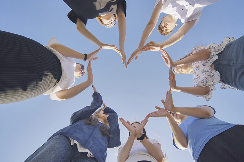 School children make a heart shape from their hands.