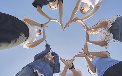 School children make a heart shape from their hands