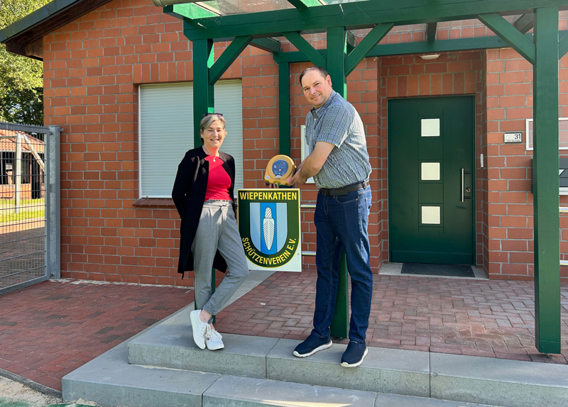 Tatjana Kirchner vom Verein Mein Herz in Stade e.V. übergibt den AED-Defibrillator an Dennis Arnold, Präsident des Schützenvereins Wiepenkathen e.V. (Foto: Sven Ulrich)